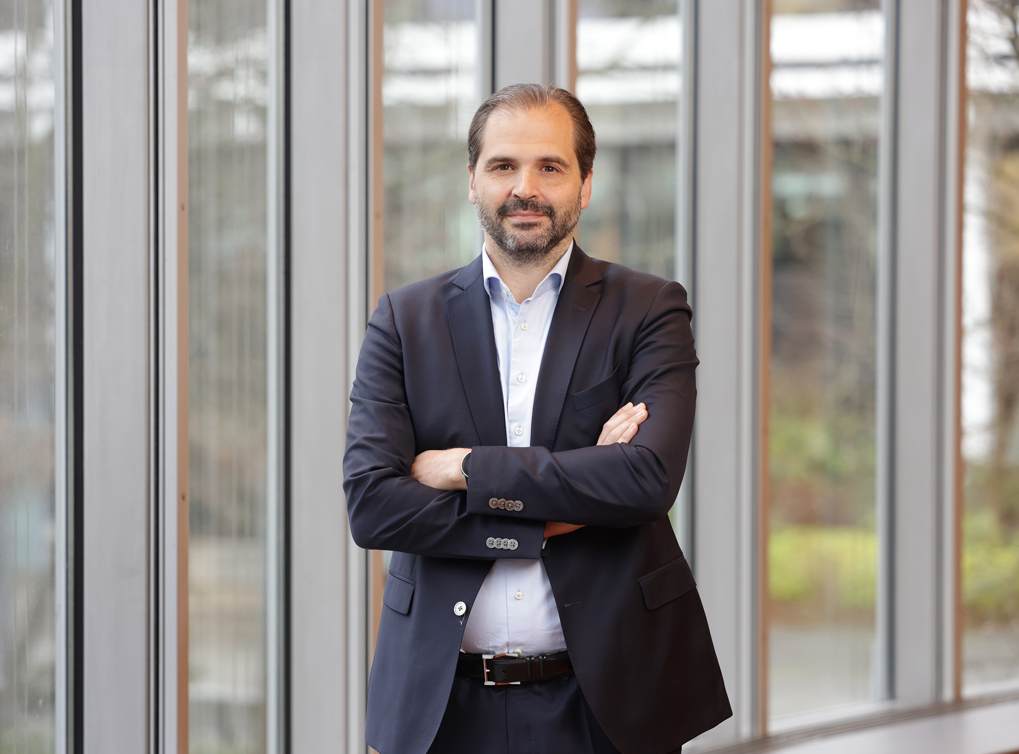 Prof. Martin Scheffel lehnt an Glaswand