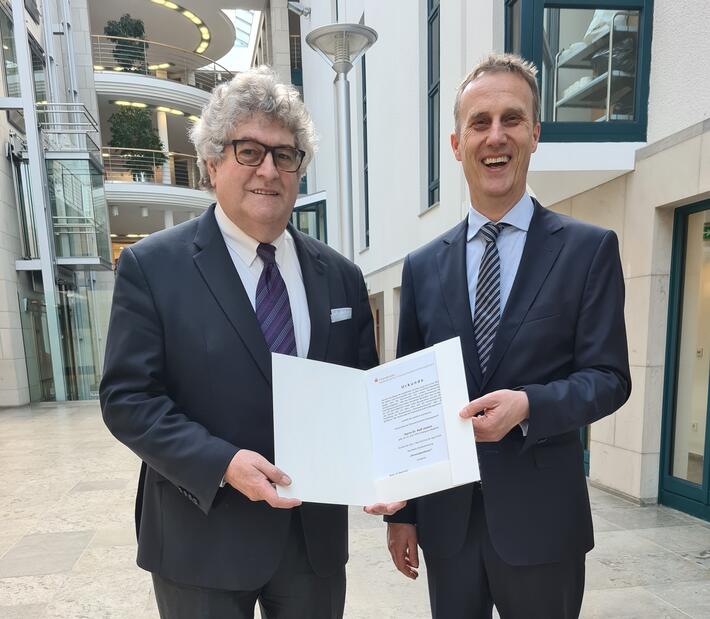 Dr. iur. Ralf Josten bekommt eine Urkunde verliehen
