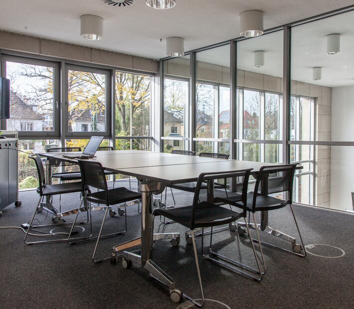 Ein Konferenztisch inmitten eines Sitzungszimmers der Hochschule