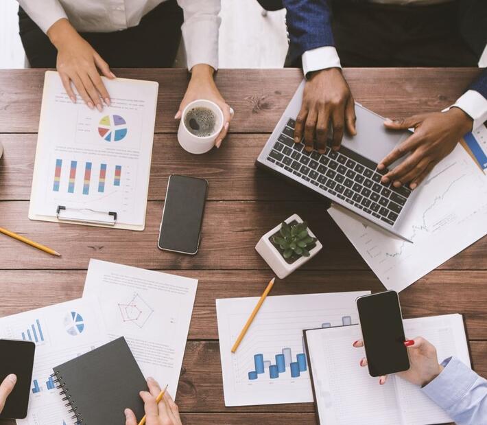 Ein Tisch, an dem vier Personen arbeiten von oben