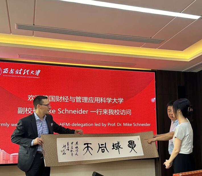 Mike Schneider bekommt in China eine Schriftrolle überreicht