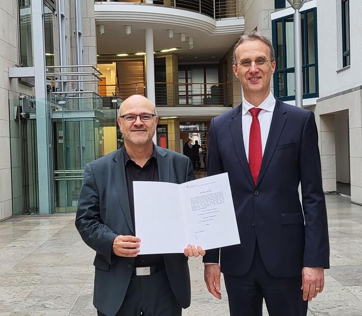 Herr Dietz und Herr Heitzer stehen im Foyer der Hochschule