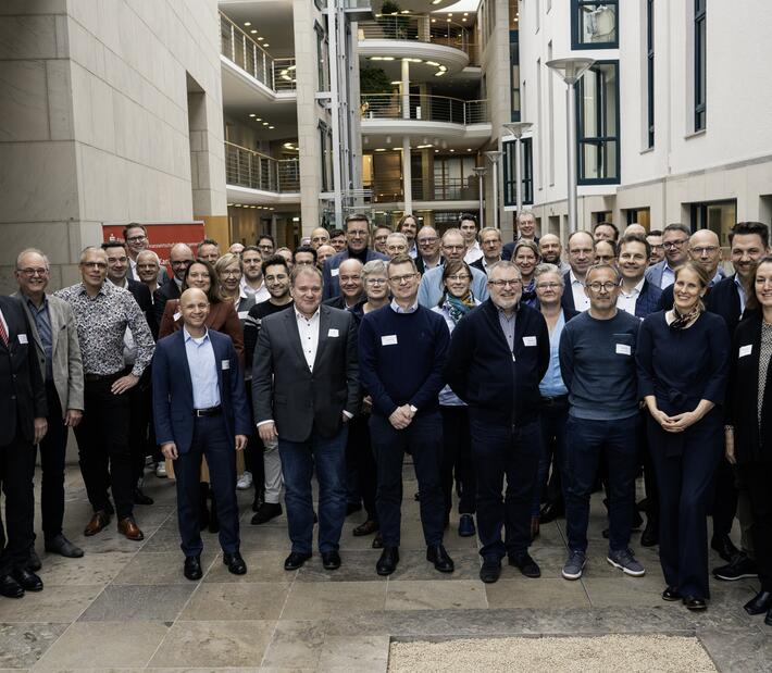 Eine Gruppe von Menschen steht im Foyer der Hochschule