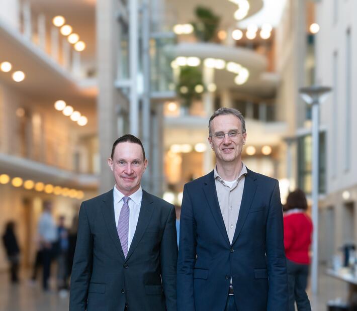 Herr Barth und herr Heitzer stehen im Foyer der Hochschule