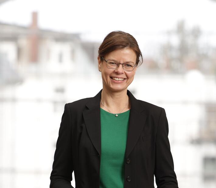 Eine formal gekleidete Frau lächelt