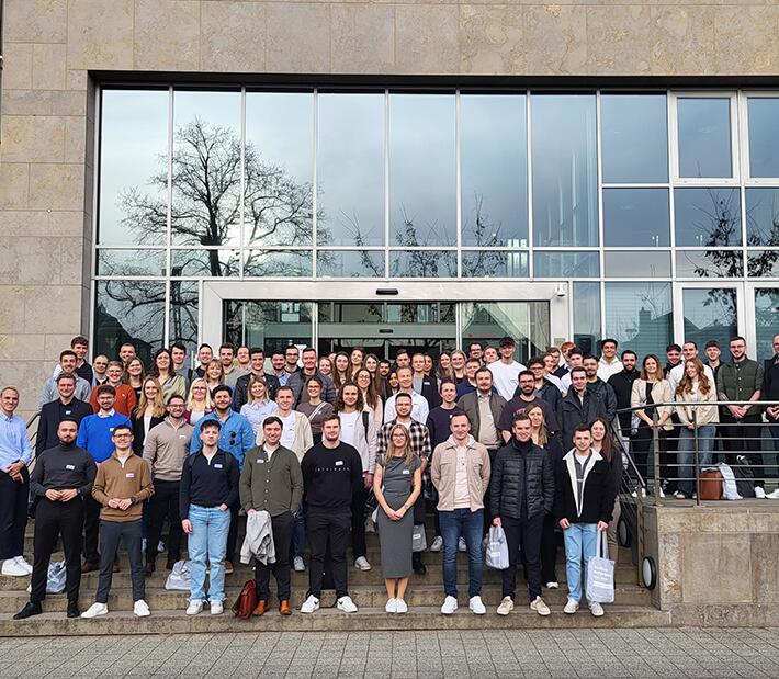 Eine grosse Gruppe junger Menschen steht vor dem Gebäude der HFM