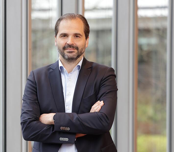 Ein mann im Anzug steht vor einem Gebäude