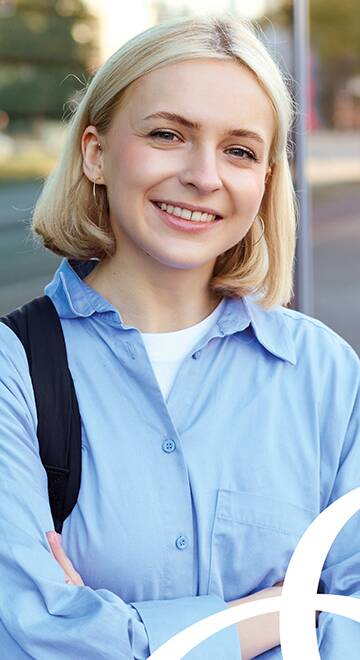 junge blonde Frau steht vor einem Gebäude