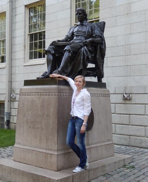MBA-Studierende steht vor der Statue von John Harvard