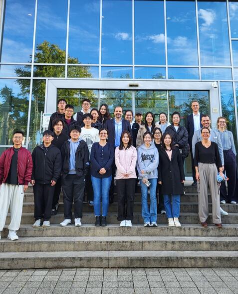 Gruppe von chinesischen Studierenden steht vor Portal der HFM.