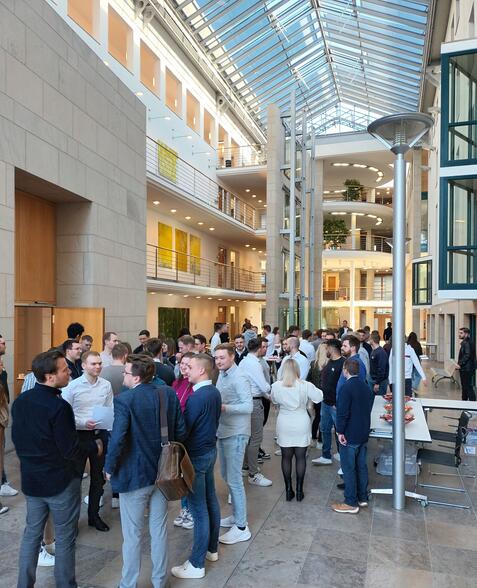 Menschen stehen im Foyer und unterhalten sich