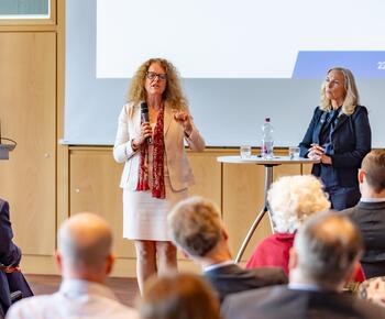 Zwei Frauen stehen en einem Stehtisch und diskutieren