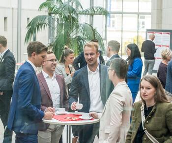 Eine Grupp von Menschen steht an Tischen