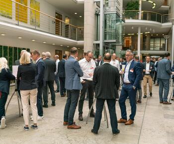 Teilnehmende vom Forum Firmenkundengeschäft unterhalten sich in kleinen Gruppen im Foyer