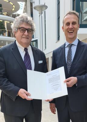 Dr. iur. Ralf Josten bekommt eine Urkunde verliehen