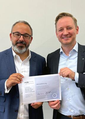 Prof. Dr. Denis Bagbasi (l.) und Christof Overkämping, CFP & Programmdirektor, Sparkassenakademie Baden-Württemberg, halten die Akkreditierungsurkunde in den Händen.