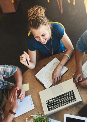 Studierende sitzen gemeinsam am Tisch und unterhalten sich