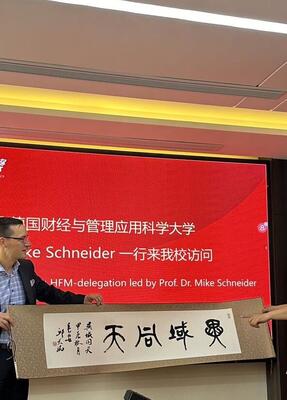 Mike Schneider bekommt in China eine Schriftrolle überreicht