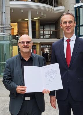 Herr Dietz und Herr Heitzer stehen im Foyer der Hochschule