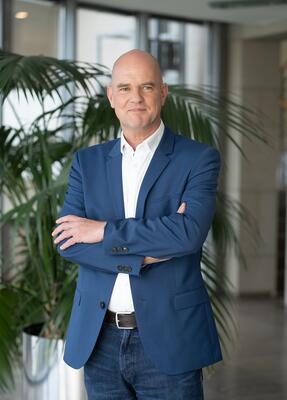 Dr. Björn C. Manstedten steht mit Armen verschränkt im Seminarraum