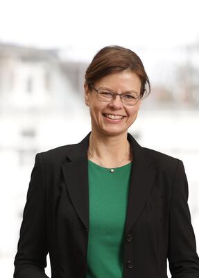 Eine formal gekleidete Frau lächelt