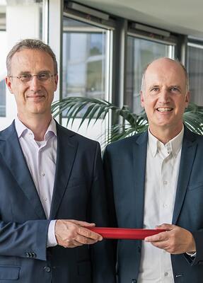 Zwei Herren lächeln in die Kamera