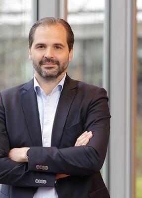 Ein mann im Anzug steht vor einem Gebäude