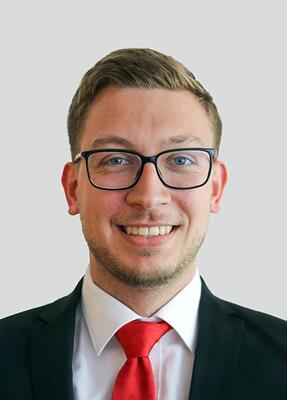 Ein junger Mann mit Brille lächelt