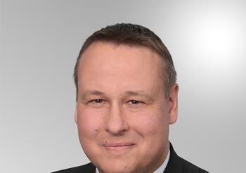 Markus Hack, Mitarbeiter der Kreissparkasse Köln, in dunklem Anzug mit gestreifter Krawatte.