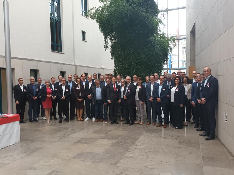 Am Symposium teilnehmende Frauen und Männer im Foyer der HFM