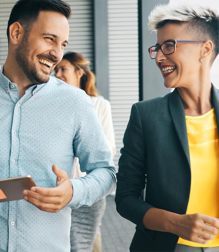 Mann und Frau in Businesskleidung lachen sich an