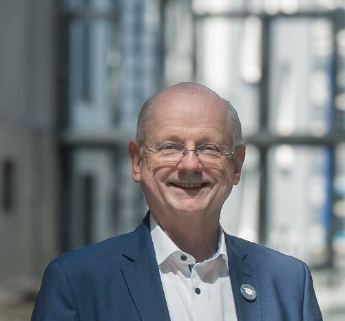 Ein Herr im Anzug lächelt